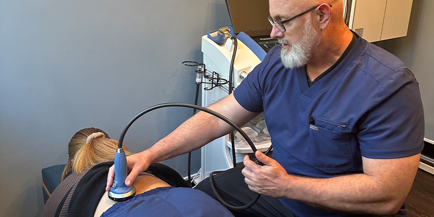 Raleigh auto accident forms for chiropractor adjusting patient's shoulder to relieve pain